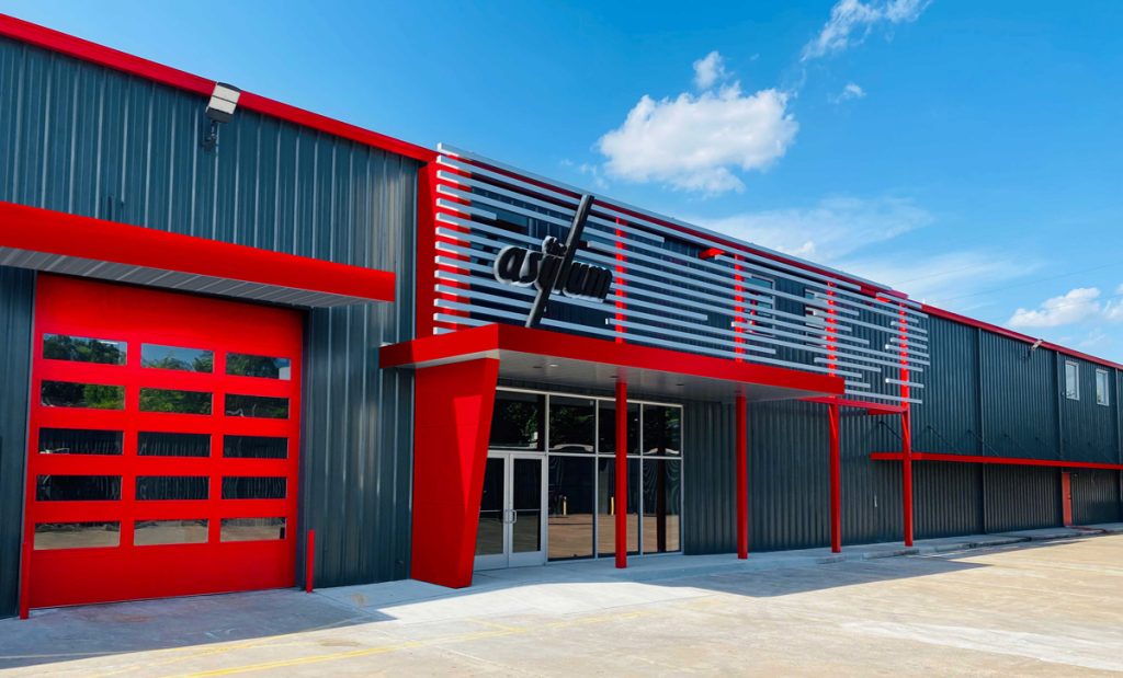 Exterior of the Asylum metal building with modern facade displaying the Asylum logo